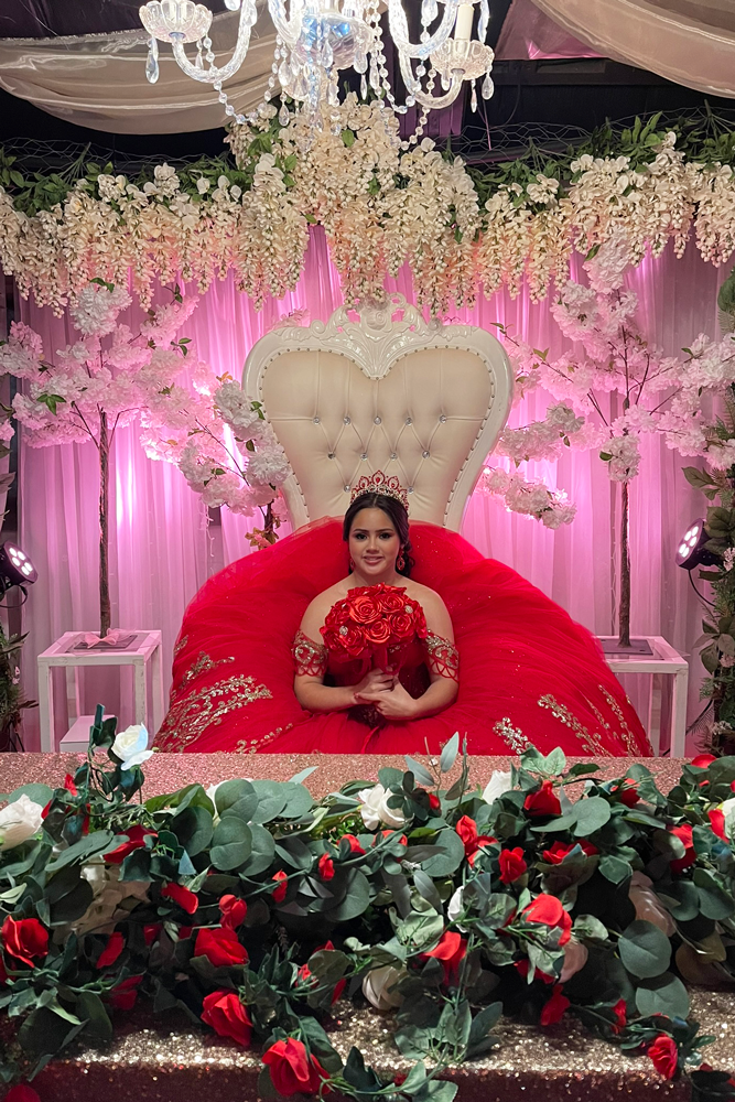 Father and daughter in garden gazebo on white throne chairs and huge floral display on head table.