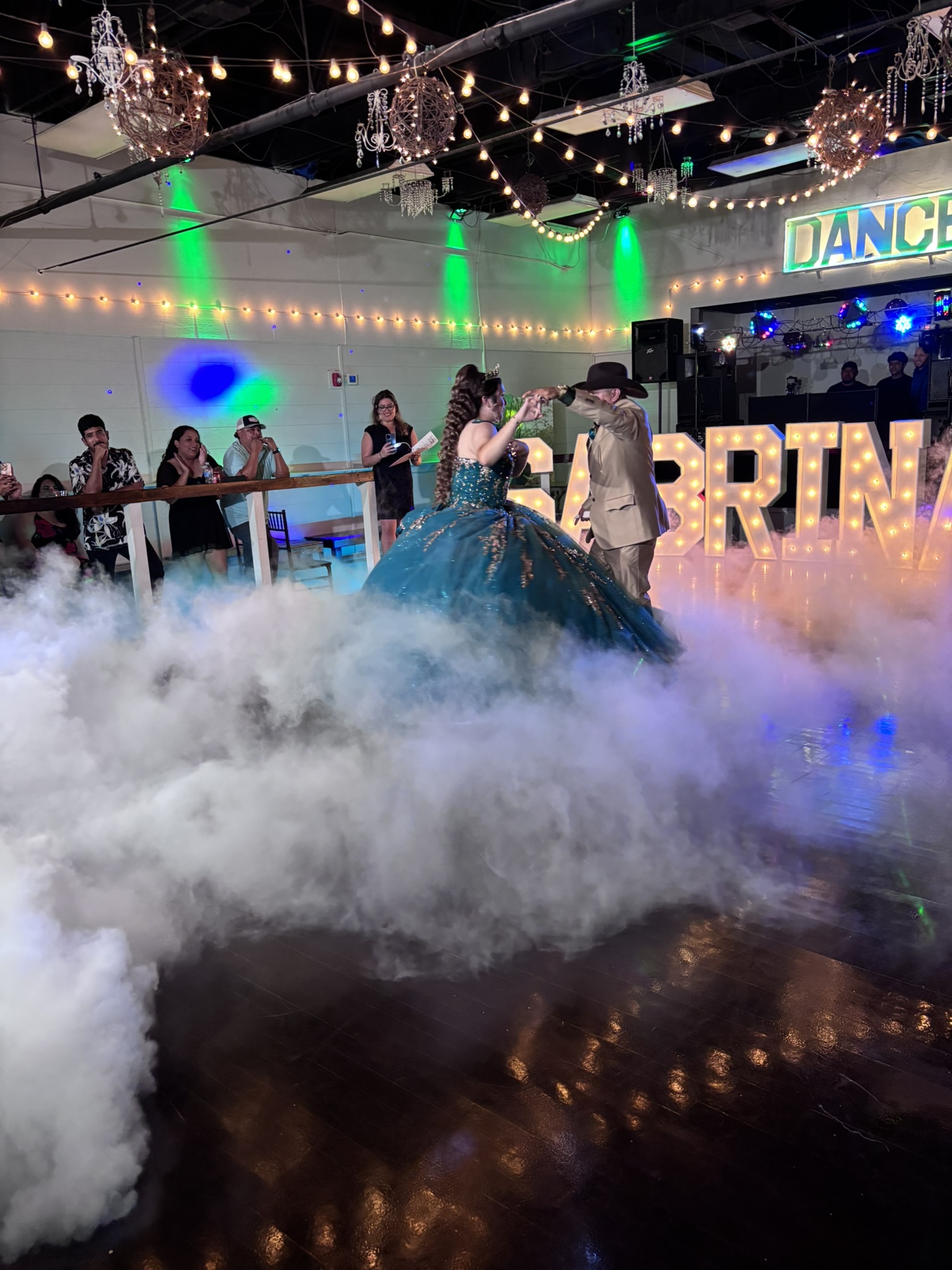 Father daughter dance on a fog filled illuminated dance floor.