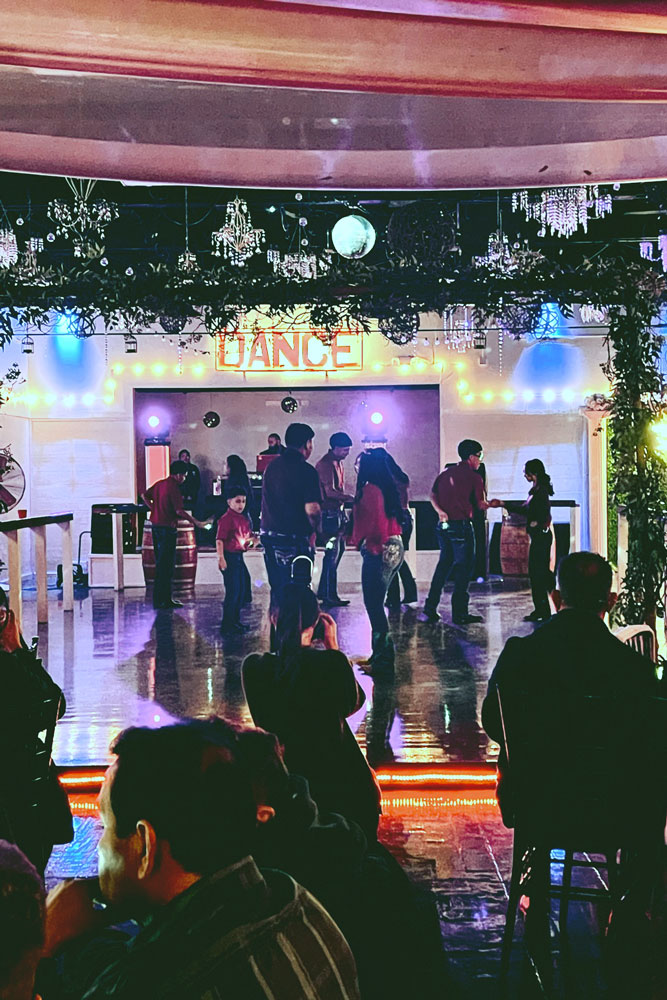 Dancers on the illuminated dance floor showing their best moves.