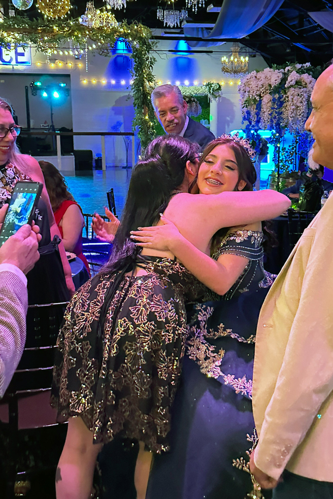 Quinceañera welcomed into the ballroom by family.