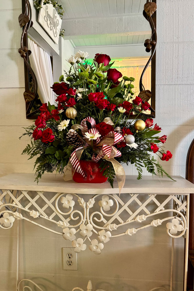 Holiday floral arrangement decorated with Christmas greenery and seasonal accents