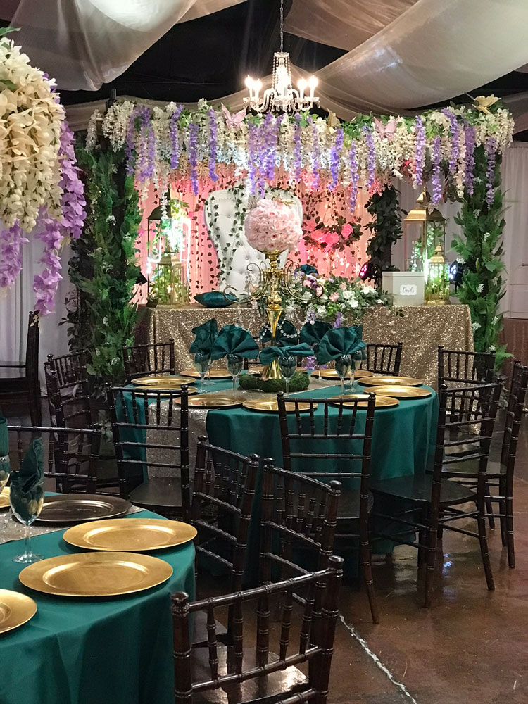 nchanted forest–inspired ballroom featuring draped greenery, warm wood tones, and romantic uplighting