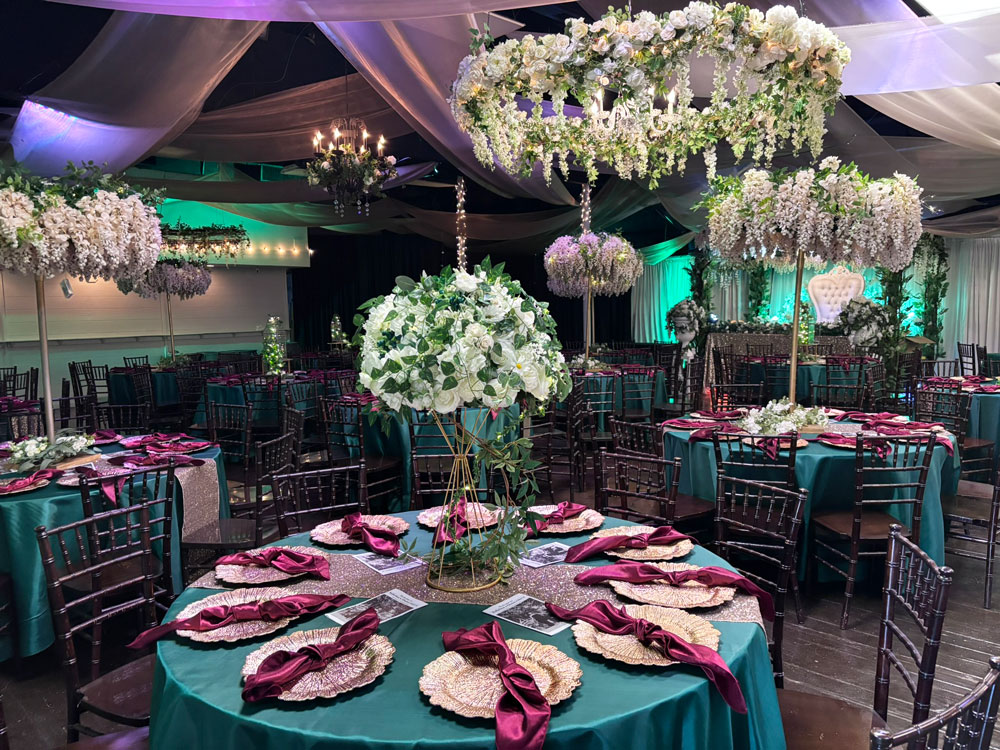 Spacious wedding ballroom featuring green uplighting and neutral accents