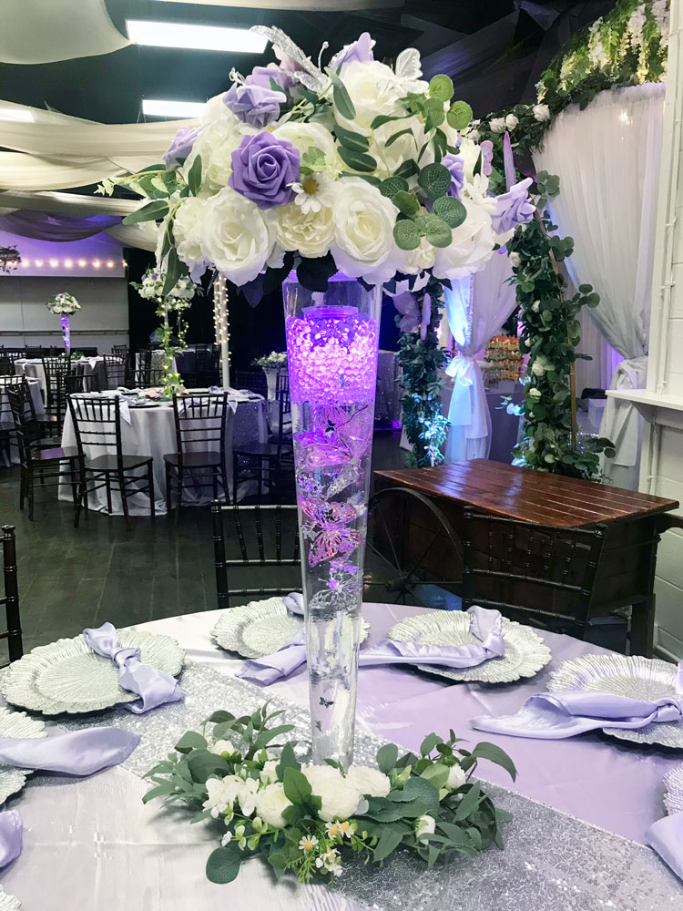 Elegant glass centerpiece featuring lavender flowers and greenery details