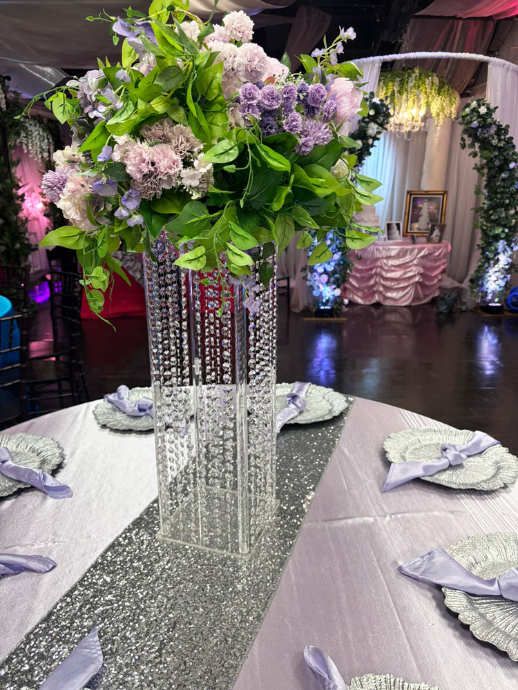 Elegant tall jewled table centerpiece featuring lavender flowers and crystal details